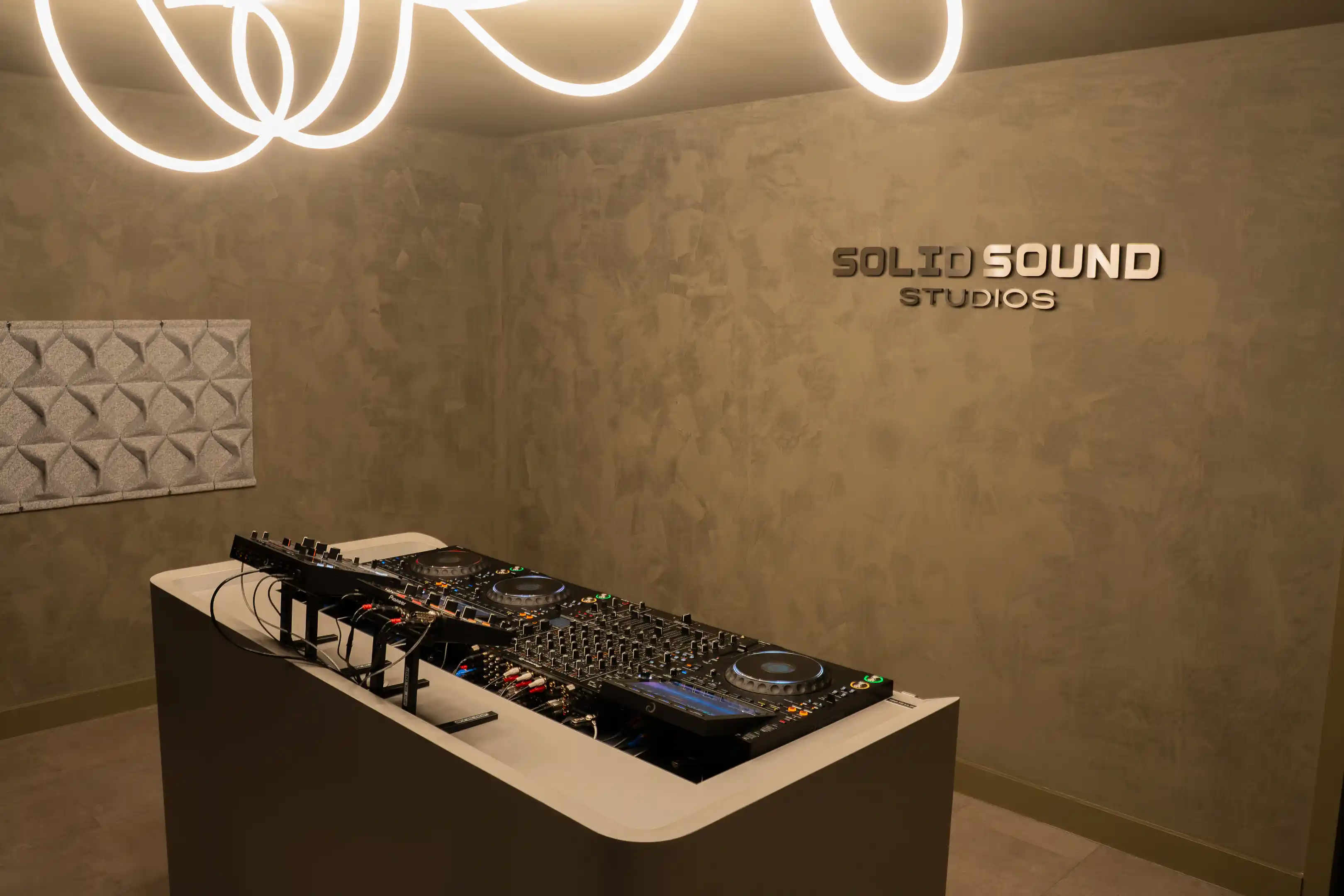 De studio met het SOLID SOUND studios-logo op de muur en de booth op de voorgrond